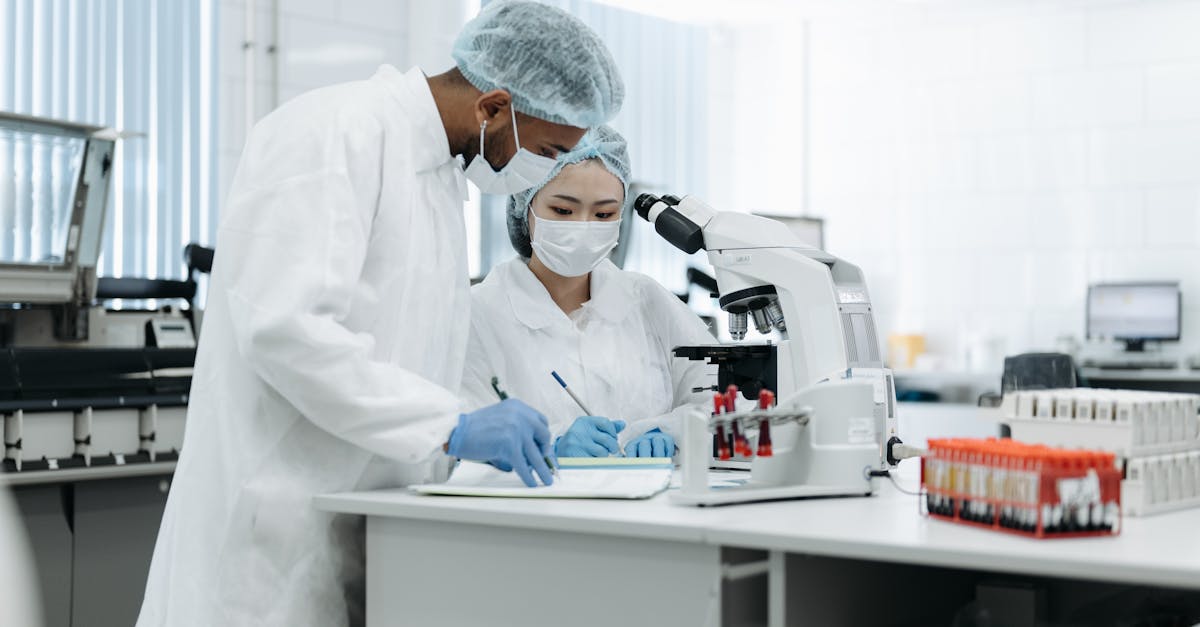 Two scientists in a laboratory conducting research with microscopes and lab equipment.